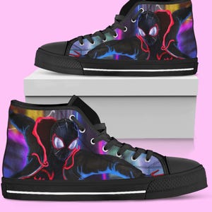 May include: Pair of high-top canvas sneakers featuring a colorful graphic of a superhero. The shoes have black soles, black laces, and silver eyelets. The design includes shades of red, blue, and purple against a black background.