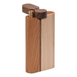 Puede incluir: Una pipa de madera con tapa con bisagras. El dugout está hecho de dos tipos de madera, uno claro y otro oscuro, con un accesorio de latón. La tapa es de madera oscura y está abierta.