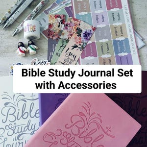 May include: A Bible study journal set with accessories, including pens, stickers, bookmarks, and journals. The journals are pink, purple, and white, with the words "Bible Study Journal" embossed on the cover. The set also includes small figurines and a candle.