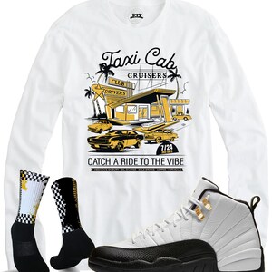 May include: A white long-sleeve shirt with a Taxi Cab Cruisers graphic, black and white checkered socks, and white and black sneakers. The shirt features a retro design with cars and the text "Catch a Ride to the Vibe."