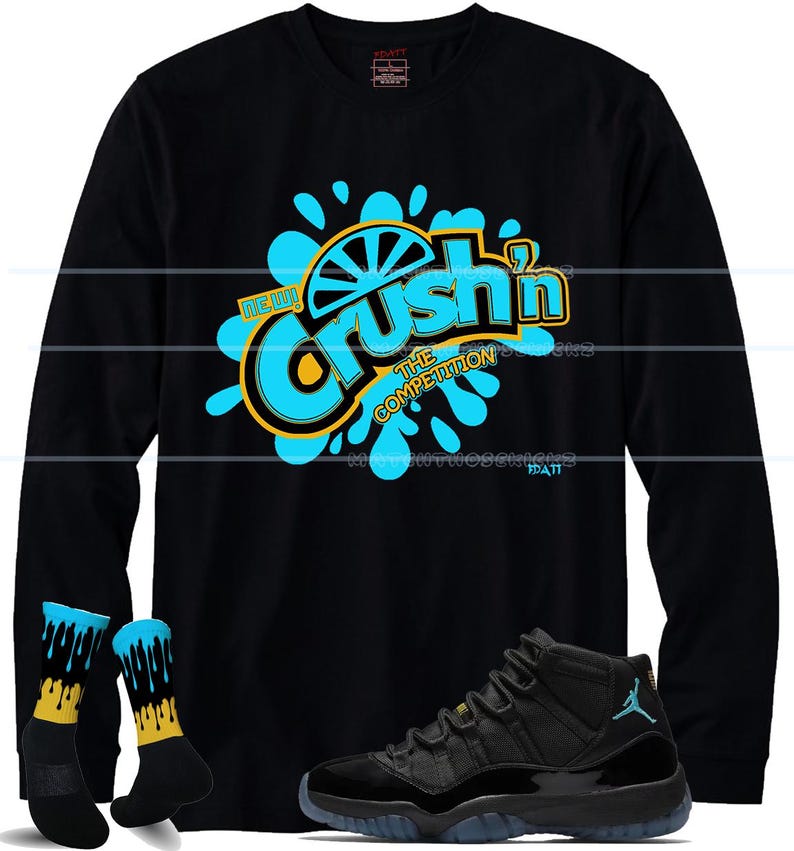 Puede incluir: Camiseta negra de manga larga con un gr&aacute;fico turquesa y amarillo que dice "Crush'n The Competition". La imagen tambi&eacute;n muestra calcetines negros y turquesas con un dise&ntilde;o amarillo y zapatillas negras y turquesas.