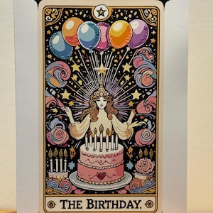 May include: A birthday-themed tarot card illustration. The card features a woman with a halo, a pink cake with candles, and colourful balloons. The text "THE BIRTHDAY" is at the bottom. The card has a white border with star accents.
