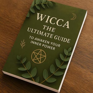 May include: A green book titled "Wicca The Ultimate Guide To Awaken Your Inner Power." The cover features gold accents, including a crescent moon, a pentagram, and leaf illustrations. The book is on a wooden surface.