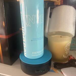 Puede incluir: Una lata de bebida energ&eacute;tica Red Bull Winter Edition azul claro con texto y gr&aacute;ficos blancos. La lata est&aacute; sobre un expositor giratorio negro y azul. El texto de la lata dice "Iced Vanilla".