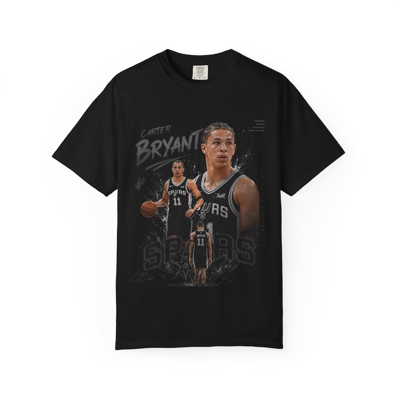 May include: Black t-shirt featuring a basketball player graphic. The design includes the name "Carter Bryant" and the word "Spurs". The player is wearing a jersey with the number 11. The shirt has a crew neck and short sleeves.