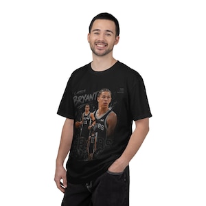 May include: Black t-shirt featuring a graphic of a basketball player with the name "Carter Bryant" and the number 11. The player is wearing a black and silver jersey. The shirt is worn by a person.