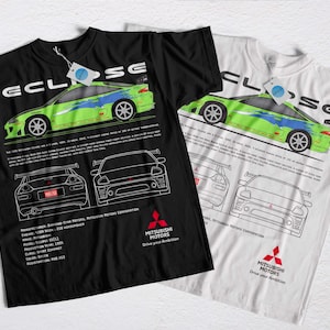 May include: Two t-shirts, one black and one white, with a green and blue car graphic and the word "ECLIPSE". Below the car are line drawings of the car's rear and front. The Mitsubishi Motors logo is at the bottom of the design.