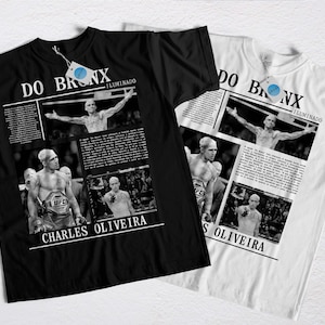 Pode incluir: T-shirts pretas e brancas com imagens de Charles Oliveira. As camisas exibem o texto "DO BRONX" e "CHARLES OLIVEIRA", juntamente com fotos de ação do lutador de UFC. Uma camisa é preta, a outra é branca.