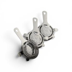 May include: Three stainless steel cocktail strainers with heart-shaped handles and perforated strainer heads. One strainer has a coiled spring around the strainer head. The strainers are on a white background, suggesting barware.