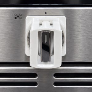 May include: A white plastic stove knob cover with a rectangular center cutout, installed over a metallic silver stove control knob. The cover features a hinged top section and is mounted on a brushed stainless steel appliance control panel.