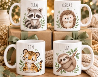 Könnte beinhalten: Vier weiße Keramiktassen mit Illustrationen eines Waschbären, eines Igels, eines Tigers und eines Faultiers. Über jedem Tier steht ein Name: ELLA, OSKAR, BEN und LIA. Die Motive sind mit grünen Blättern und kleinen Herzen verziert.