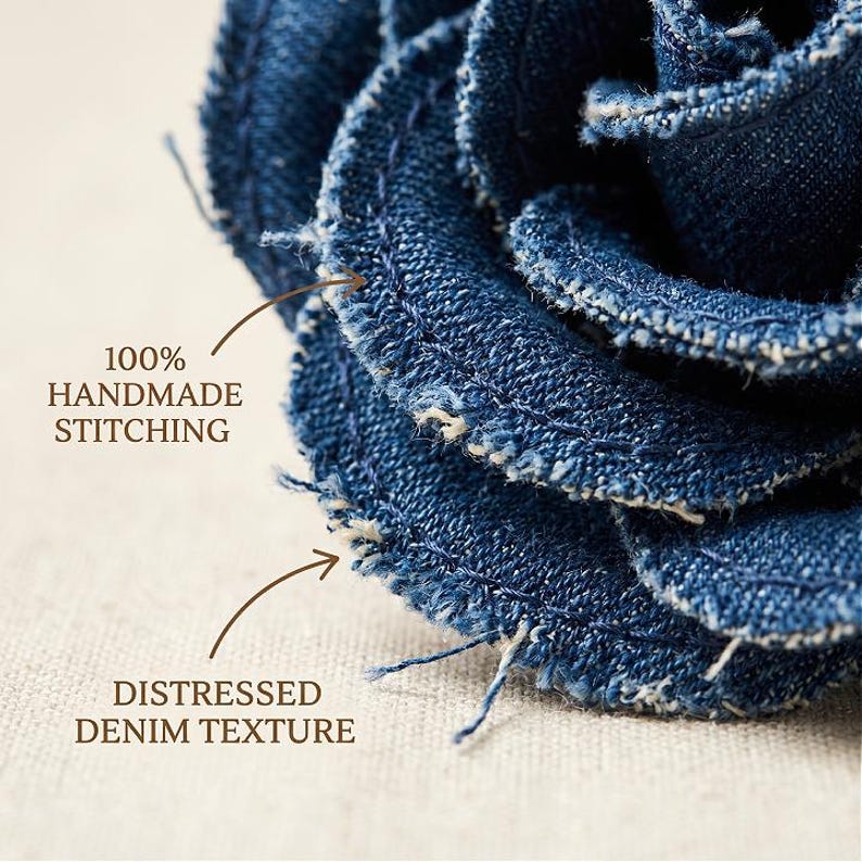 Pode incluir: Close-up de uma flor de ganga feita &agrave; m&atilde;o com uma textura desgastada. A flor &eacute; feita de tecido de ganga azul escuro com costuras vis&iacute;veis e bordas desfiadas. O texto na imagem diz "100% HANDMADE STITCHING" e "DISTRESSED DENIM TEXTURE".