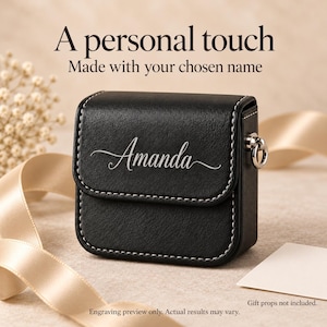 Op de afbeelding: Een zwart vierkant etui met witte stiksels en een zilveren metalen ring aan de zijkant. De voorflap is voorzien van de naam Amanda in een cursief lettertype. De tekst erboven luidt A personal touch Made with your chosen name.