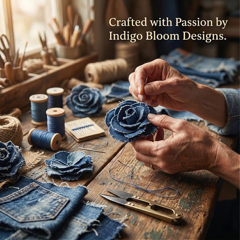 Pode incluir: Close-up de m&atilde;os costurando uma rosa de ganga. A imagem mostra tecido de ganga, carret&eacute;is de linha azul, agulhas e tesouras sobre uma superf&iacute;cie de madeira. O texto na imagem diz: "Crafted with Passion by Indigo Bloom Designs."