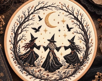 May include: A circular embroidery hoop containing a fabric panel with a hand-stitched design of three figures in black dresses and pointed hats holding hands in a circle, surrounded by a dark tree branch frame, a crescent moon, and birds.