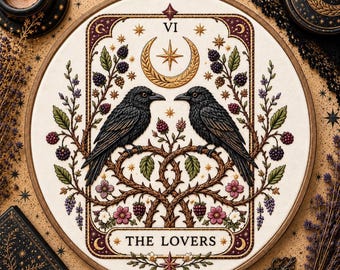 May include: A circular embroidery hoop featuring a tarot card design titled THE LOVERS. Two black crows face each other perched on thorny branches with blackberries, green leaves, and small pink flowers. A gold crescent moon and star sit above.