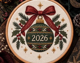 May include: A circular wooden embroidery hoop containing a fabric piece with a hand-stitched design of a dark green Christmas ornament featuring the year 2026 in white thread, topped with a large red bow, surrounded by embroidered holly and pine.