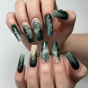 Puede incluir: Uñas postizas largas en forma de ataúd con un diseño detallado de paisaje forestal. El arte incluye pinos de color verde oscuro, picos de montañas y la silueta de un pequeño ciervo sobre un fondo degradado crema y verde con gotas de agua 3D transparentes.