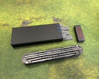 May include: A black case with gray measuring tools and a black rectangular block with red text. The case is open, revealing several gray measuring tools. The tools are arranged in a linear fashion. The text on the case reads "LMSZ".