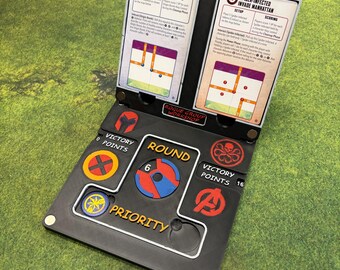 May include: A black and gray Crisis Protocol game board with the text "Crisis Protocol" at the top. The board features game instructions, round and priority indicators, and various faction symbols. The board is set on a green surface.