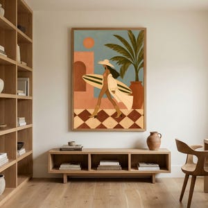 Op de afbeelding: Een ingelijste muurkunstprint met een gestileerde illustratie van een persoon met een hoed met brede rand en laarzen die een surfplank draagt. De scène bevat een terracotta gebouw, een palmboom, een zon en een bruin-witte geblokte vloer.