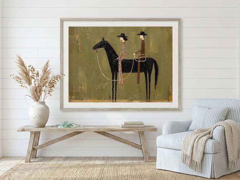 May include: A framed wall art print featuring a stylized black horse with two figures riding on its back. The figures wear hats and long garments, one in a brown tone and the other in a patterned brown. The background is a textured olive green.