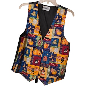 May include: A sleeveless vest featuring a multi-colored patchwork pattern with Halloween-themed illustrations including pumpkins, bats, spiders, and the text "BOO" and "EEK". The garment has a black interior lining and a black button closure.