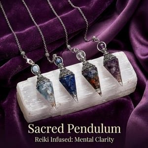 May include: Four pointed crystal pendulums on silver-toned chains, each featuring a decorative metal cap and a unique stone composition. The text reads Sacred Pendulum Reiki Infused: Mental Clarity. The pendulums are arranged in a row.