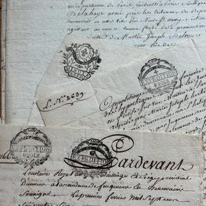 May include: Antique documents with handwritten script and ornate seals. The papers are aged with visible wear and tear, featuring faded ink and a vintage aesthetic. The seals include intricate designs and text, adding to the historical feel.