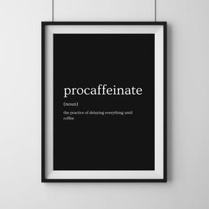 Puede incluir: Un estampado en blanco y negro enmarcado con la palabra "procaffeinate" en blanco, definida como la práctica de posponer todo hasta el café. El estampado está en un marco negro y cuelga de una pared blanca.