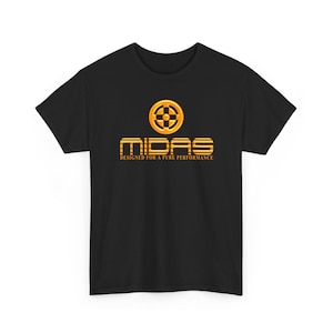 Puede incluir: Camiseta negra con un logotipo dorado y naranja. El logotipo dice "MIDAS" y "DESIGNED FOR A PURE PERFORMANCE". El logotipo presenta un diseño circular con un patrón en forma de cruz en el centro.