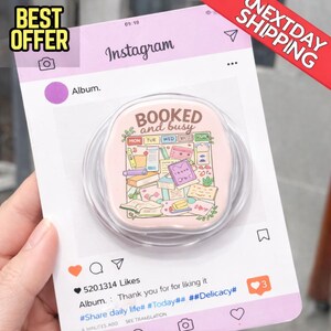 May include: A pink pop socket with the words "BOOKED and busy" and a design of books and stationery. The pop socket is on a mock Instagram post with the text "BEST OFFER" and "NEXTDAY SHIPPING".