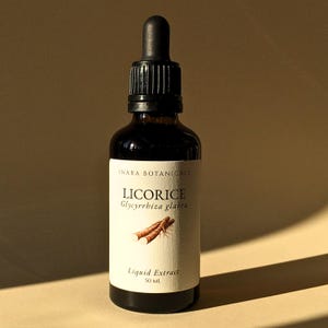 May include: A dark amber glass bottle of liquid extract with a black dropper. The label reads "INARA BOTANICALS" and "LICORICE Glycyrrhiza glabra" with an illustration of licorice root. The bottle contains 50 ml of liquid extract.