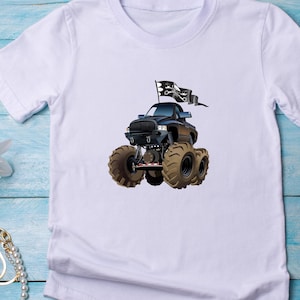 Puede incluir: Camiseta blanca con una ilustraci&oacute;n de dibujos animados de un cami&oacute;n monstruo negro con neum&aacute;ticos marrones de gran tama&ntilde;o. El cami&oacute;n tiene una bandera negra con un dise&ntilde;o de calavera y huesos cruzados. La camiseta est&aacute; hecha de un material suave y c&oacute;modo.