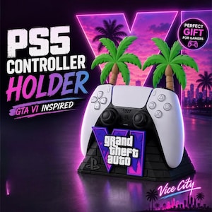 May include: A black and white PS5 controller holder featuring two green palm trees and a purple and blue Grand Theft Auto VI logo on the front. The base is black with a PlayStation logo, and the text reads PS5 CONTROLLER HOLDER GTA VI INSPIRED.