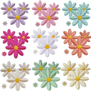 Könnte beinhalten: Eine Sammlung von neun gestickten Blumenaufnähern in einem Raster angeordnet. Jedes Set besteht aus zwei größeren gänseblümchenartigen Blüten mit gelber Mitte und einer kleineren passenden Blüte in verschiedenen Farben wie Lila, Pink, Blau, Weiß und Grün.