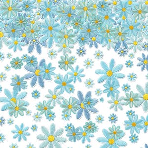 Könnte beinhalten: Ein Muster aus gestickten Gänseblümchen-Aufnähern mit hellblauen Blütenblättern und leuchtend gelben Mitten. Die Blumen variieren in der Größe und sind auf einem weißen Hintergrund verstreut, was ein dichtes Blumenarrangement ergibt.