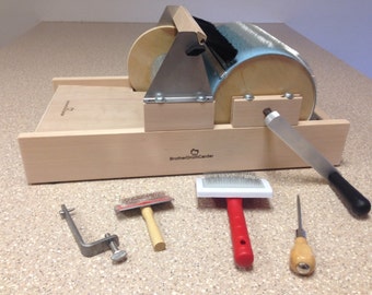 May include: A wooden drum carder with a blue brush roller, a metal clamp, a red handled brush, a wooden handled brush, and a wooden handled needle tool. The carder has the text "Brother Drum Carder" engraved on the side.