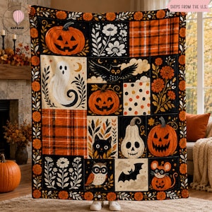 Op de afbeelding: Een rechthoekige plaid met een patchworkontwerp met Halloween-motieven, waaronder pompoenen, een wit spook, een zwarte kat, een uil, een vleermuis en een muis. Het patroon bevat oranje en zwarte ruiten, bloemmotieven en stippen.