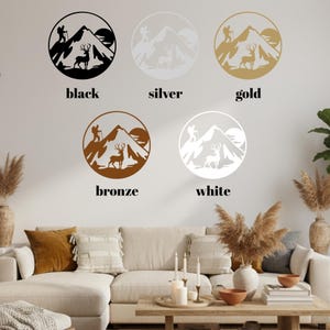 May include: Wall art featuring mountain and deer silhouettes in black, silver, gold, bronze, and white. Each design is circular, with a hiker, deer, mountain, and sun. The word "black", "silver", "gold", "bronze", and "white" are written below each design.