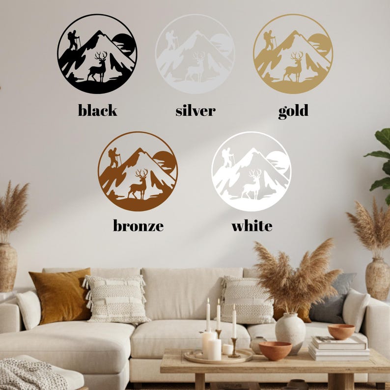May include: Wall art featuring mountain and deer silhouettes in black, silver, gold, bronze, and white. Each design is circular, with a hiker, deer, mountain, and sun. The word "black", "silver", "gold", "bronze", and "white" are written below each design.