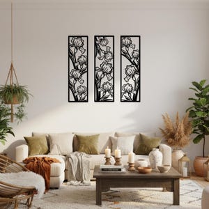 May include: Three black metal wall art panels, each featuring a stylized iris flower design. The panels are rectangular and arranged vertically, creating a cohesive decorative set for a living room or similar space.