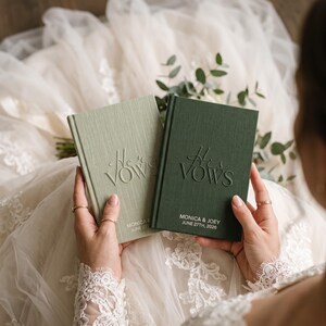 Puede incluir: Dos libros de votos de tapa dura con cubiertas texturizadas. El libro verde salvia claro tiene grabado el texto Her Vows, y el libro verde bosque oscuro tiene His Vows. Ambos incluyen los nombres Monica & Joey y la fecha 27 de junio de 2026.