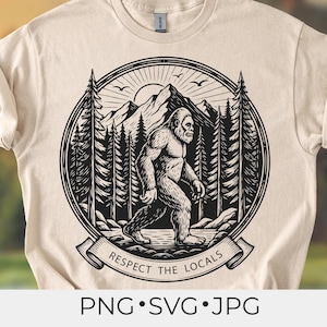 May include: A beige t-shirt featuring a black and white illustration of Bigfoot walking in a forest scene. The design is circular, with mountains, trees, and a rising sun. The text "RESPECT THE LOCALS" is on a banner below the image.