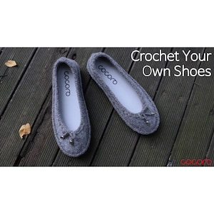 Op de afbeelding: Twee grijze gehaakte ballerina's met het woord "cocoro" op de binnenzool. De schoenen hebben een klein strikdetail op de neus en worden gepresenteerd op een houten oppervlak. De tekst "Crochet Your Own Shoes" is ook zichtbaar.