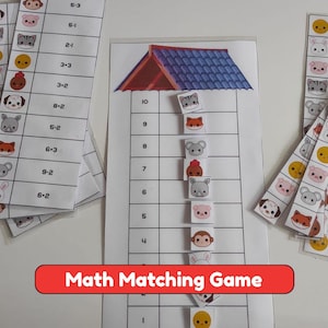 May include: A math matching game featuring printed paper strips with animal illustrations and subtraction equations. A central vertical chart displays numbers one through ten beneath a blue roof graphic, with small square animal tiles placed on the grid.