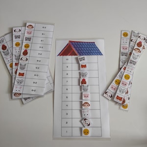 May include: Educational game featuring animal-themed cards and a house-shaped board. The cards display various animal faces and numbers, while the board has numbered slots. The game is designed for learning and matching.