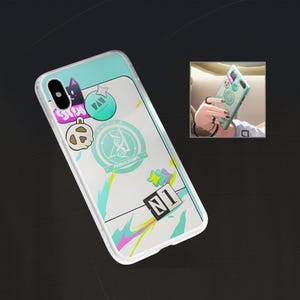 Könnte beinhalten: Transparente Handyhülle mit türkisfarbenem Oberteil und weißem Hintergrund, verziert mit bunten Aufklebern. Zu den Aufklebern gehören eine Katze, ein Stern und ein Abzeichen mit dem Text "PEGABASUS". Die Hülle hat einen transparenten Rand.