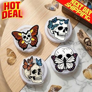 Op de afbeelding: Vier decoratieve schedelontwerpen met vlinder- en bloemaccenten. Eén schedel heeft een vlinderontwerp, een andere heeft vlinders op het hoofd en twee andere hebben vlindervleugels. De tekst "HOT DEAL" is ook aanwezig.
