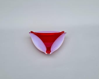 May include: A decorative glass bowl with a unique petal design. The bowl features a vibrant red interior and soft lavender-colored petals. The bowl's shape is reminiscent of a flower, adding a touch of elegance.